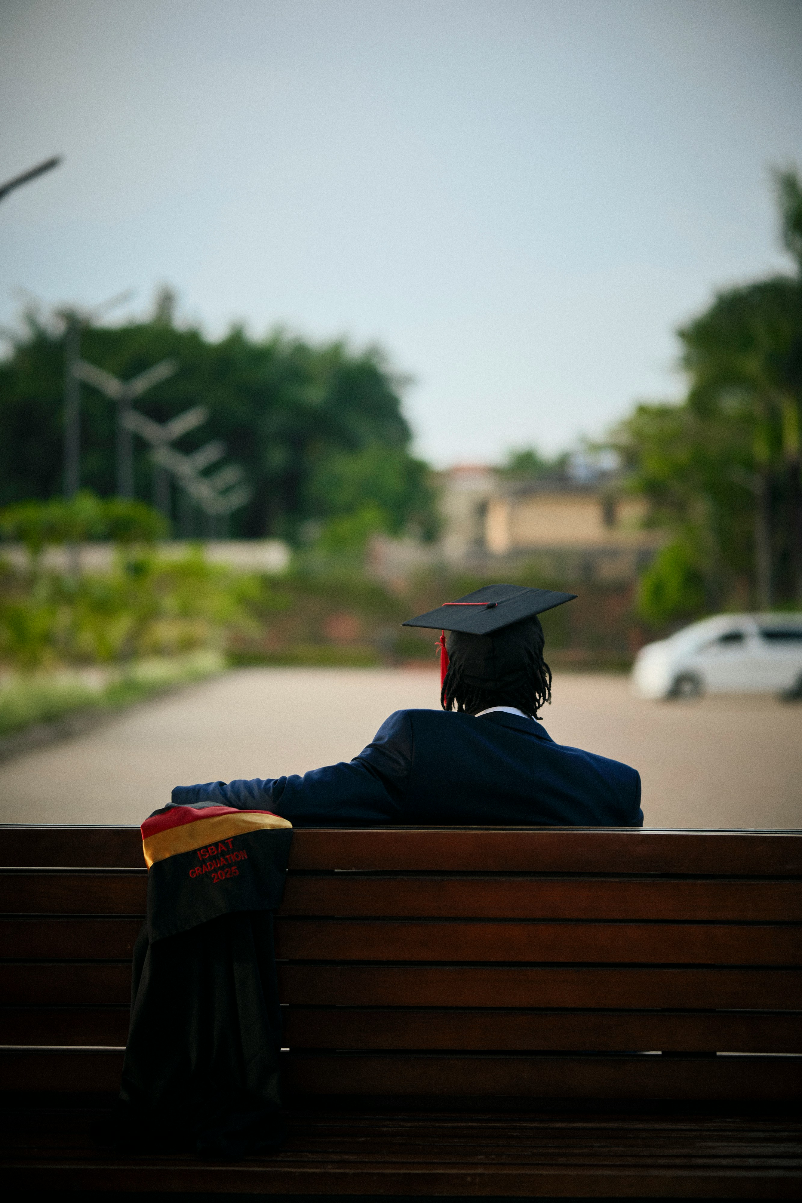 Graduate seated outdoors in academic regalia